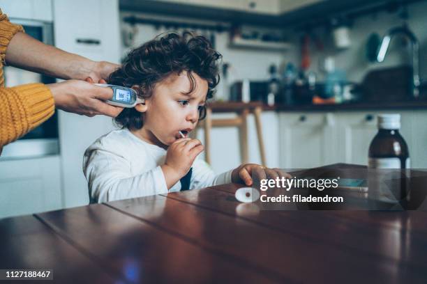 measuring little boy's temperature - baby ear infection stock pictures, royalty-free photos & images