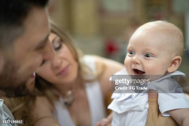 madre a hijo padre y bebé que se divierte - bautizo fotografías e imágenes de stock