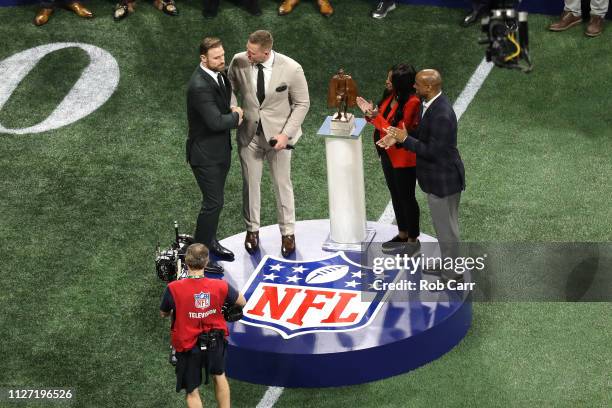 Watt of the Houston Texans presents the Walter Payton NFL Man of the Year trophy to Chris Long of the Philadelphia Eagles prior to Super Bowl LIII...