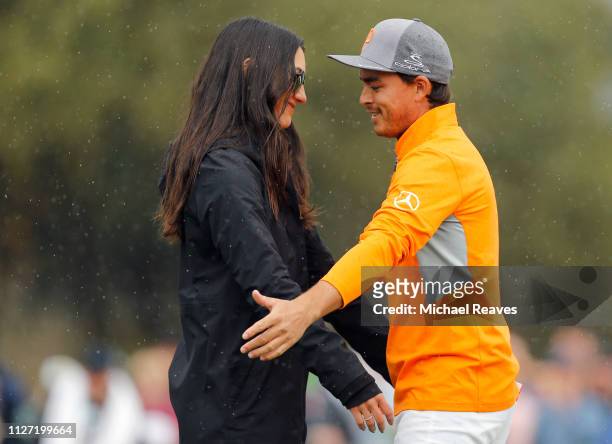 Rickie Fowler is met and congratulated by his fiancé Allison Stokke on the 18th green after winning the Waste Management Phoenix Open at TPC...