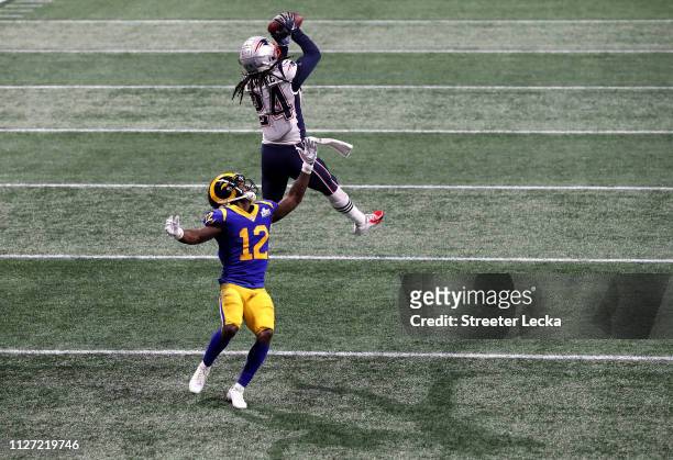 Stephon Gilmore of the New England Patriots catches a fourth quarter interception on a pass intended for Brandin Cooks of the Los Angeles Rams during...