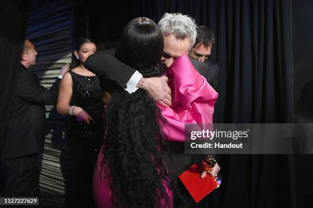 In this handout provided by A.M.P.A.S., presenter Angela Bassett poses with Best Foreign Language Film winner Alfonso Cuaron backstage during the...