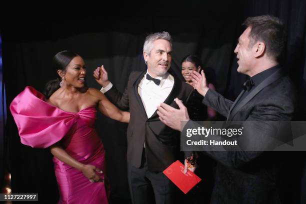 In this handout provided by A.M.P.A.S., presenter Angela Bassett poses with Foreign Language Film winner Alfonso Cuaron and presenter Javier Bardem...