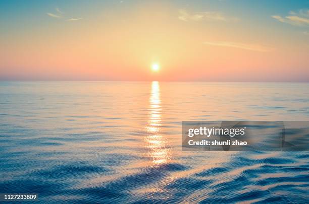 sunset at sea - golden clouds stock-fotos und bilder