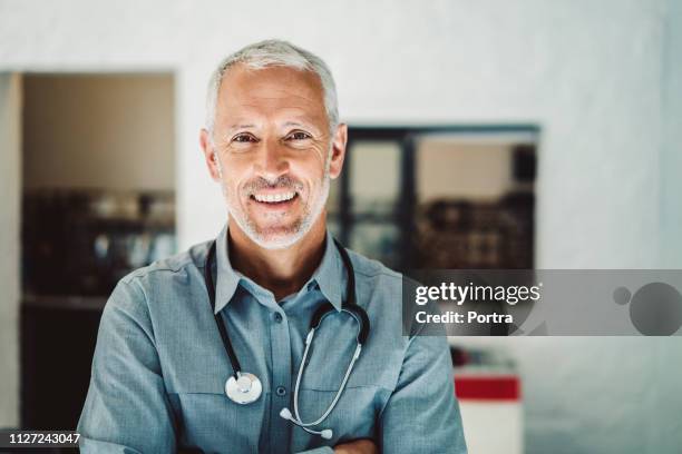 doctor with stethoscope smiling in clinic - white shirt stock pictures, royalty-free photos & images