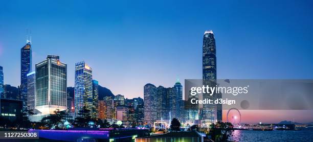 the iconic night view of the central business district in hong kong with contemporary skyscrapers along victoria harbour - central district hong kong stock pictures, royalty-free photos & images