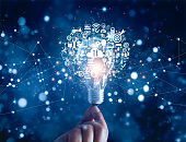 Hand holding light bulb and business digital marketing innovation technology icons on network connection, blue background
