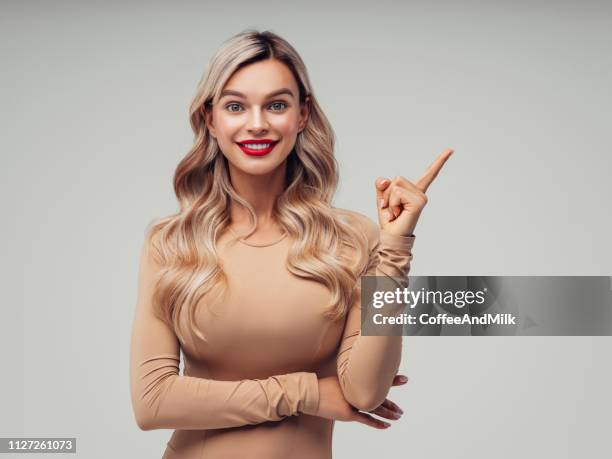 beautiful woman pointing at side - presenter isolated stock pictures, royalty-free photos & images