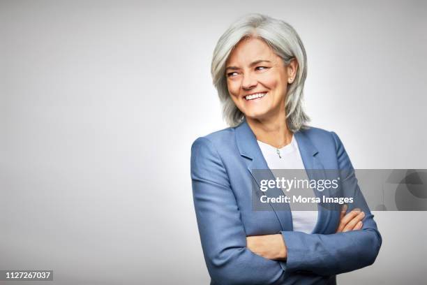 happy businesswoman with arms crossed looking away - mirar hacia el otro lado fotografías e imágenes de stock