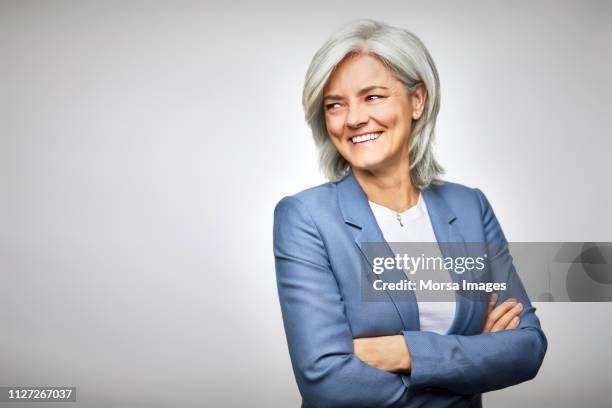 happy businesswoman with arms crossed looking away - woman white background foto e immagini stock