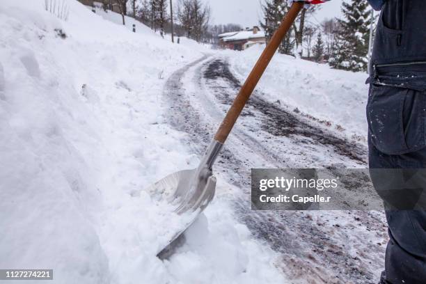 hiver - déneiger avec une pelle - temps qu'il fait stock-fotos und bilder