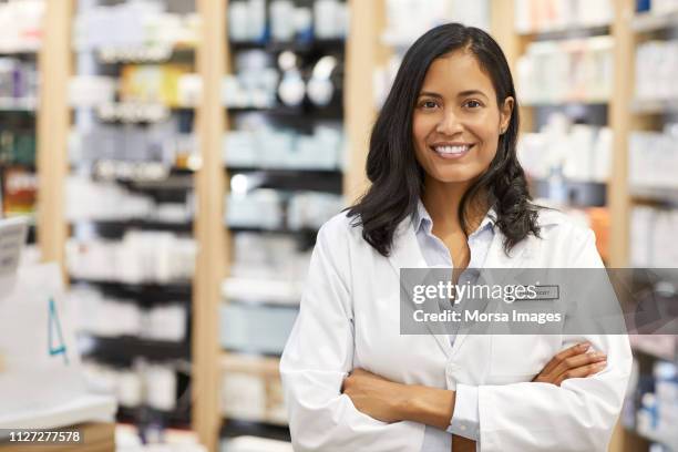 portrait of pharmacist with arms crossed at store - pharmacist fotografías e imágenes de stock