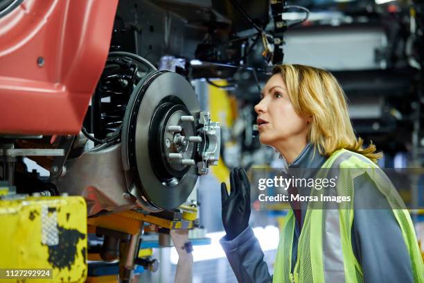 blond female engineer checking vehicle at factory - automotive manufacturing stock pictures, royalty-free photos & images