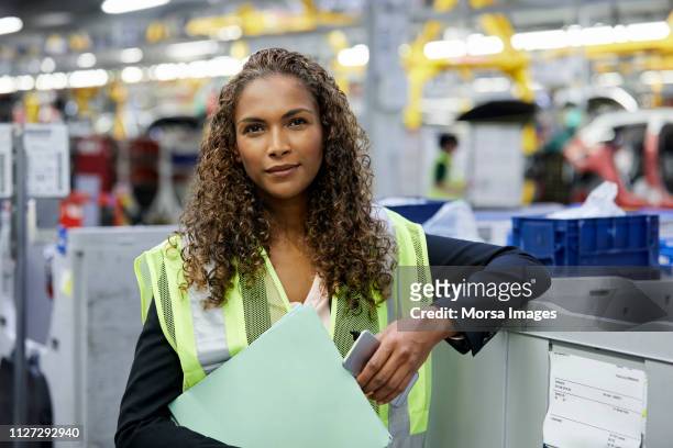 engineer holding file and smart phone in car plant - production line worker stock pictures, royalty-free photos & images