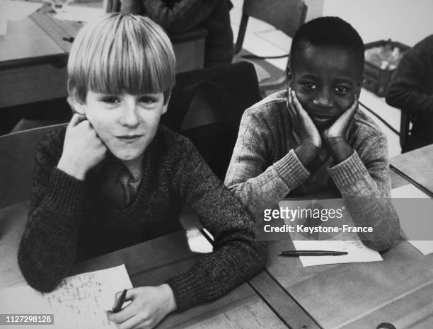 Un enfant blanc et un enfant noir assis côte à côte à l'école de Wolverhampton, Royaume-Uni, le 8 mars 1968.