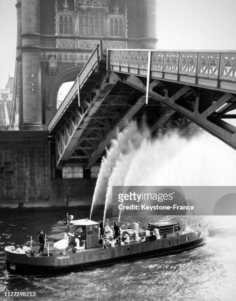 Un bateau-pompe lance de l'eau sur le Tower Bridge pour éviter qu'il ne chauffe de trop, à Londres, Royaume-Uni, le 2 juillet 1968.