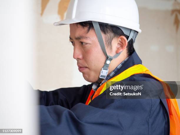 木の板に釘を打ってアジアの大工 - 工事　日本人 ストックフォトと画像