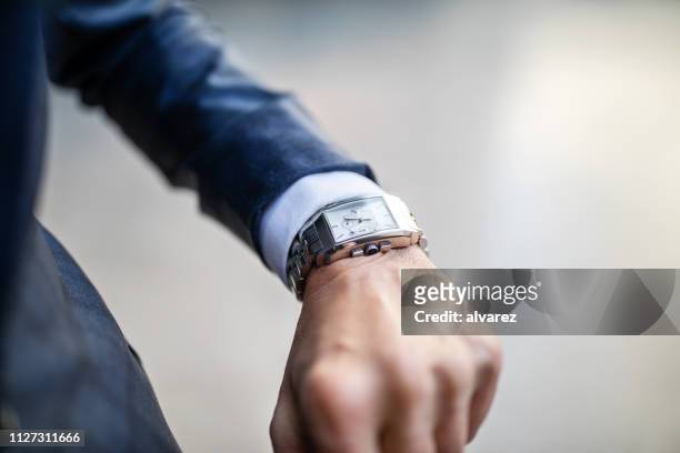 uomo d'affari che guarda questo orologio - orologio da polso foto e immagini stock
