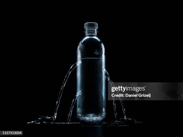 plastic water bottle with bullet holes - wassermangel stock-fotos und bilder