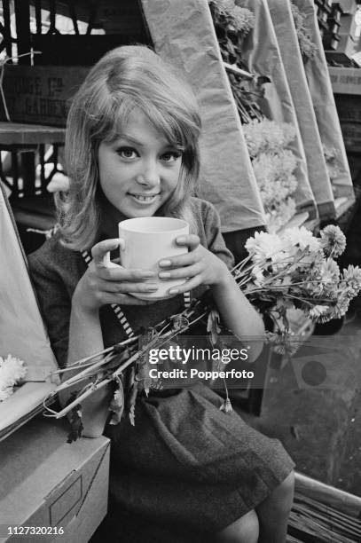 English model Pattie Boyd pictured with a mug of tea during a visit to Covent Garden market in Covent Garden, London in September 1963.