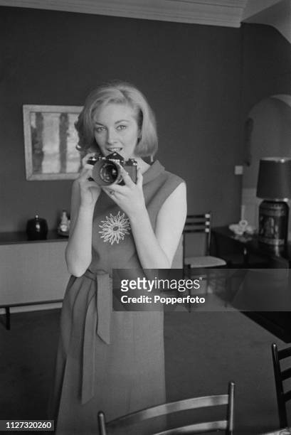 Italian actress Daniela Bianchi pictured holding a Nikon SLR camera at home in her apartment in May 1963. Daniela Bianchi currently stars as Tatiana...