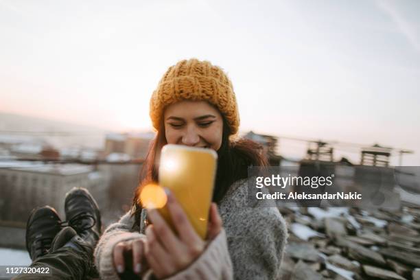 young couple sitting on top of the city - city breaks winter stock pictures, royalty-free photos & images