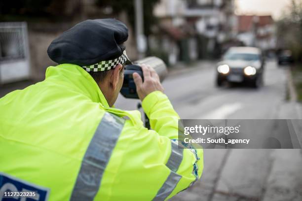verkeer politieagent werken op straat - lasergun stockfoto's en -beelden