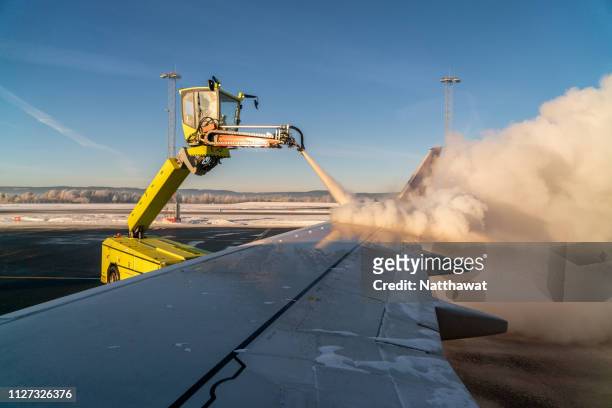 view of de-icing a plane wing process from airplane window - de ices stock pictures, royalty-free photos & images