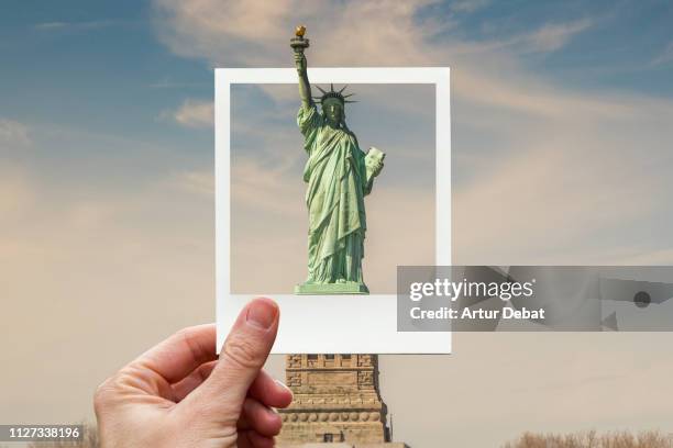 framing the statue of liberty in new york with polaroid picture from personal perspective. - statue of liberty in new york city stock pictures, royalty-free photos & images