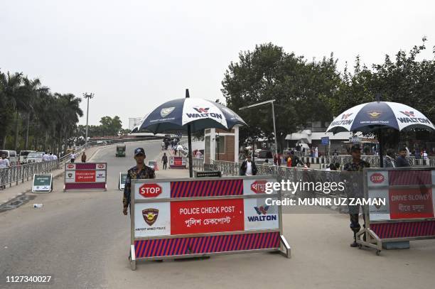 Bangladeshi security personnel stand guard at a check point along a road entrance to the Hazrat Shahjalal International Airport in Dhaka on February...