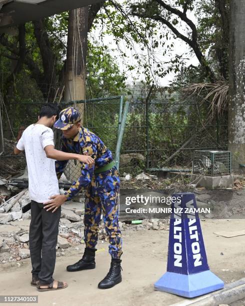 Bangladeshi security personnel search people at an entrance to the Hazrat Shahjalal International Airport in Dhaka on February 25 as Bangladesh's...