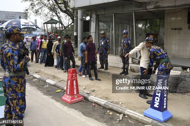 Bangladeshi security personnel search people at an entrance to the Hazrat Shahjalal International Airport in Dhaka on February 25 as Bangladesh's...