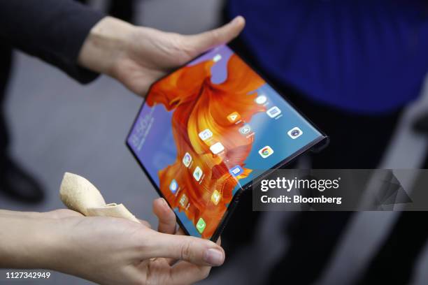 An employee demonstrates a Mate X foldable 5G mobile device at the Huawei Technologies Co. Pavilion on the opening day of the MWC Barcelona in...