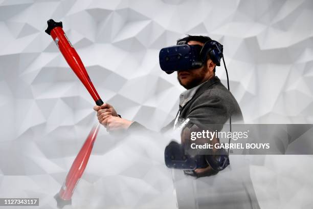 Visitor plays virtual baseball with the Vive Pro Eye virtual reality headset at the Mobile World Congress in Barcelona on February 25, 2019. - Phone...