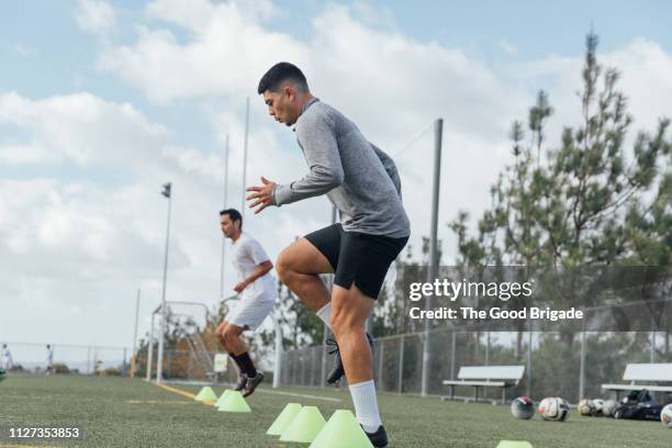 soccer players performing warm up drills on field - トレーニングドリル ストックフォトと画像