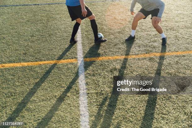 cropped shot of men playing soccer on field - two guys playing soccer stockfoto's en -beelden