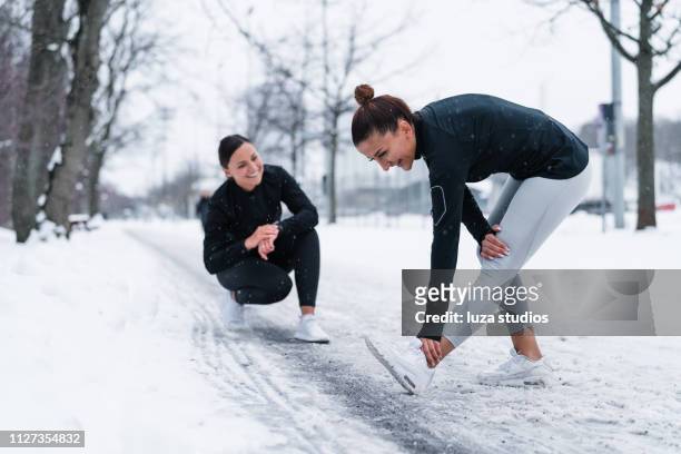 dos amigos haciendo ejercicio en la nieve - leggings fotografías e imágenes de stock