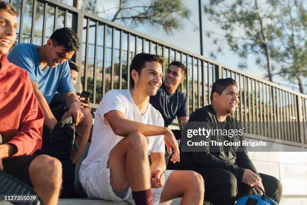 group of men sitting on bleachers at park - bleachers stock-fotos und bilder