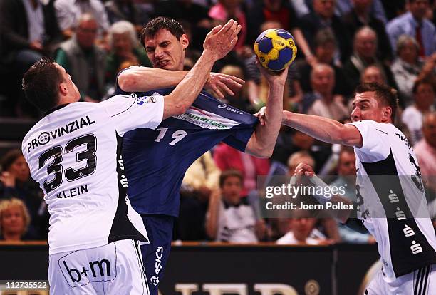 Krzysztof Lijewski of Hamburg is challenged by Dominik Klein and Filip Jicha of Kiel during the Toyota Handball Bundesliga match between THW Kiel and...