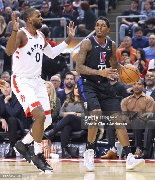 Lou Williams of the Los Angeles Clippers is covered by C.J. Miles of the Toronto Raptors in an NBA game at Scotiabank Arena on February 3, 2019 in...