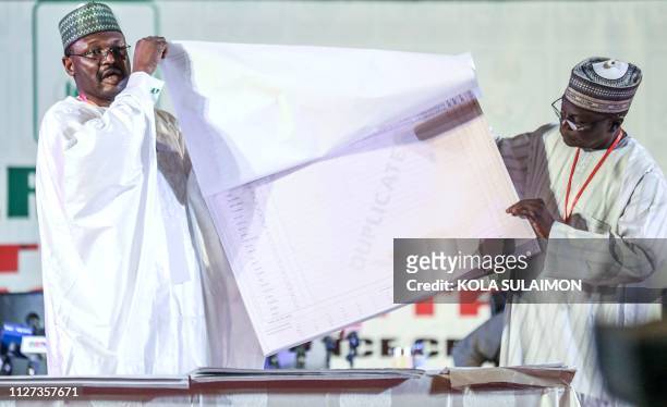 Nigeria's Independent National Electoral Commission chairman Mahmood Yakubu displays vote result sheets on February 25, 2019 in Abuja during the...