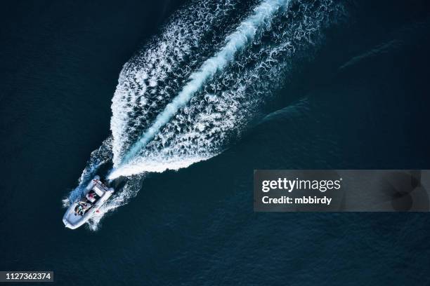 lancha de carreras a lo largo del mar abierto - bote neumático fotografías e imágenes de stock