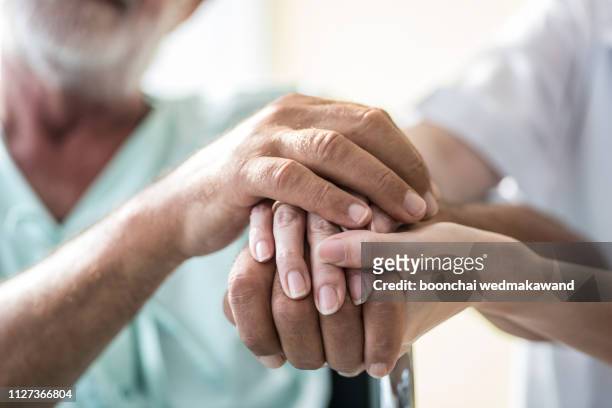 nurse holding hand of senior man in rest home - 老人醫學 個照片及圖片檔