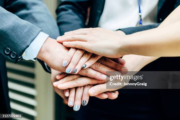 business people with hands stacked on top of each other - coalition stock pictures, royalty-free photos & images