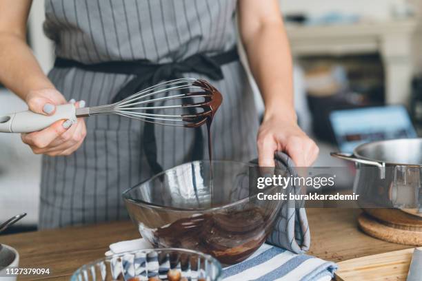 young woman mixing the chocolate bowl - chocolate biscuit cake stock pictures, royalty-free photos & images