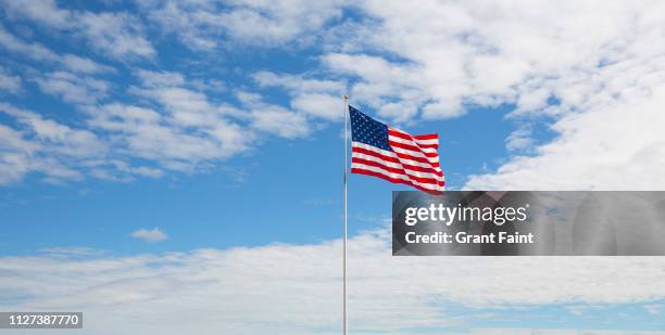american flag flying in wind. - bandera estadounidense fotografías e imágenes de stock