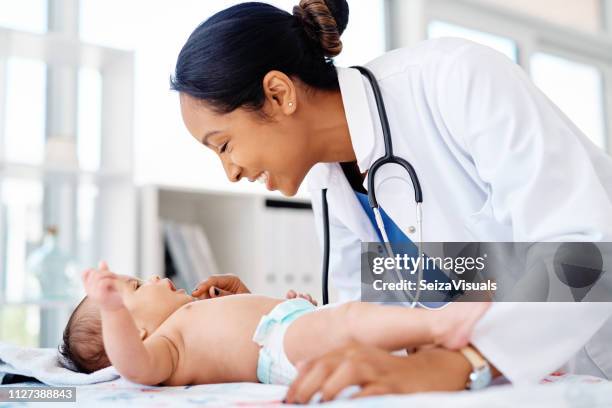keeping baby healthy and happy - newborn baby doctor stock pictures, royalty-free photos & images