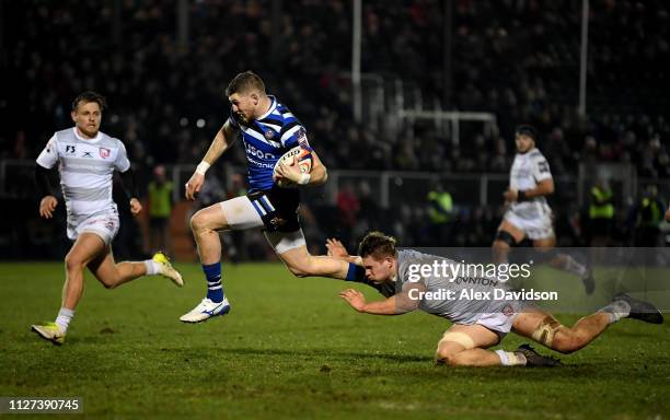 Ruaridh McConnochie of Bath Rugby beats Gareth Evans of Gloucester Rugby to score a try during the Premiership Rugby Cup match between Bath Rugby and...