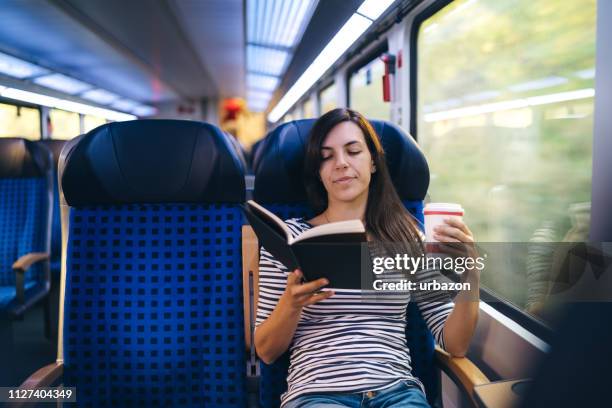 reading book on a train ride - vehicle seat stock pictures, royalty-free photos & images