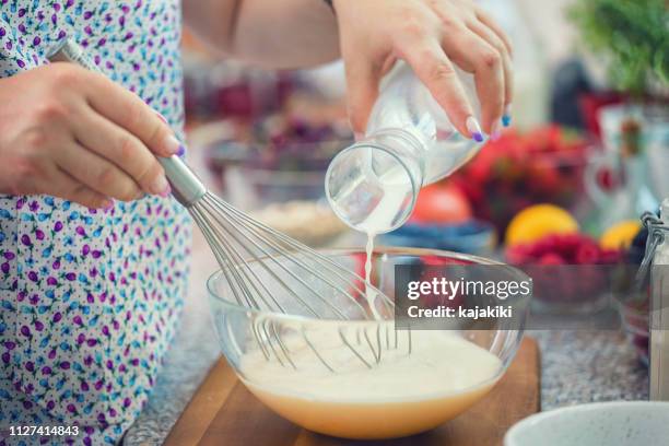 mujer preparando panqueques - batidor fotografías e imágenes de stock